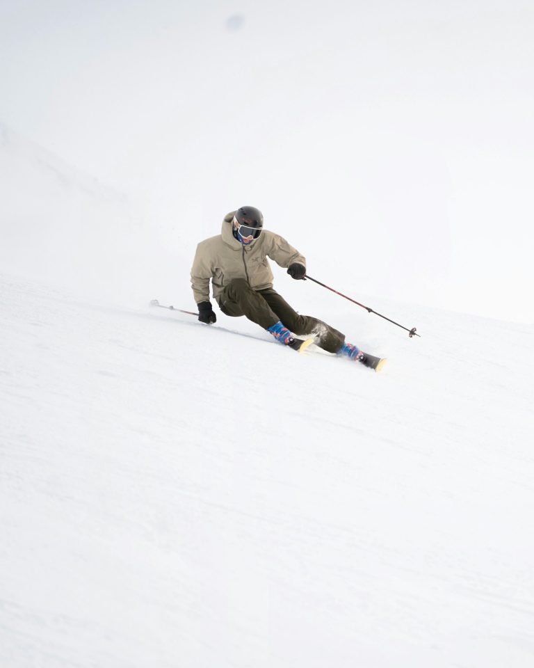 Skifahrer carvt eine steile, schneebedeckte Piste hinunter