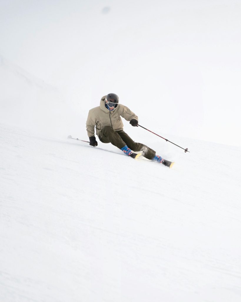 Skifahrer carvt eine steile, schneebedeckte Piste hinunter